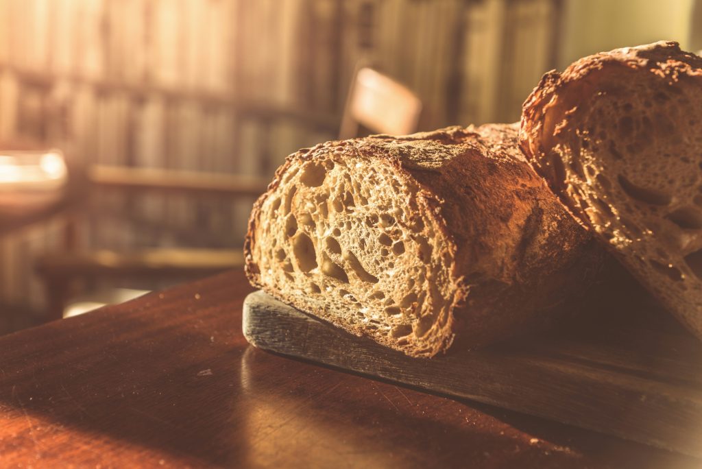 Frisch gebackenes Bauernbrot auf einem Holztisch im warmen Morgenlicht