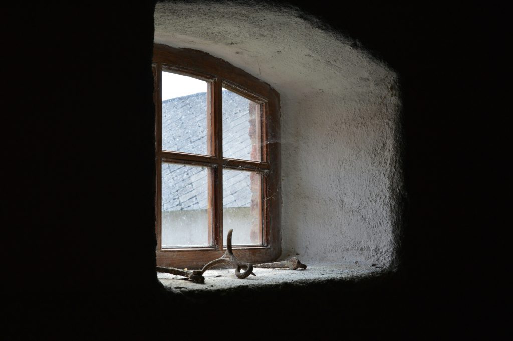 Weiches Tageslicht fällt durch ein kleines Fenster in einem alten Raum in Bad Staffelstein. Stimmungsvoll und ruhig. Sinnbild für Erinnerungen und langsamen Alltag.
