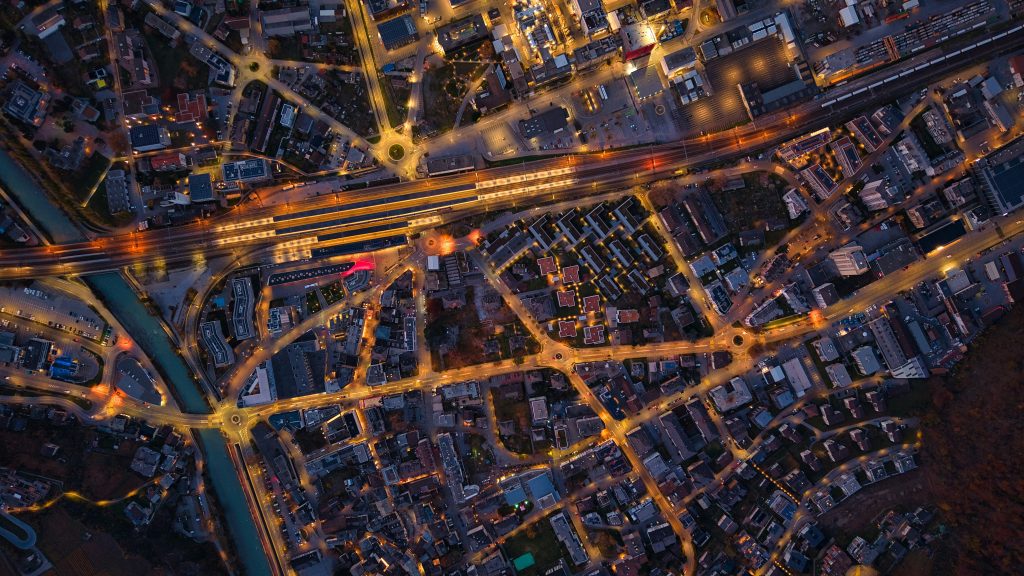 Luftaufnahme einer Stadt bei Nacht mit Straßennetz und Infrastruktur zur Analyse von Standortqualität im Tourismus