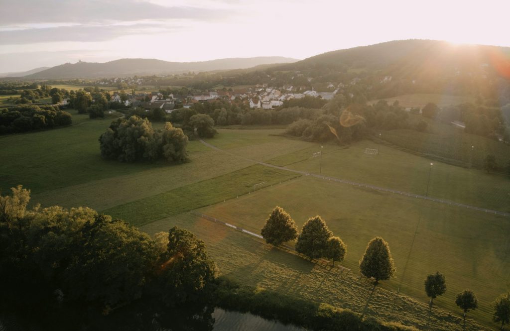 Blick über die Kulturlandschaft am Obermain mit Dorf, Wiesen und sanften Hügeln im Abendlicht